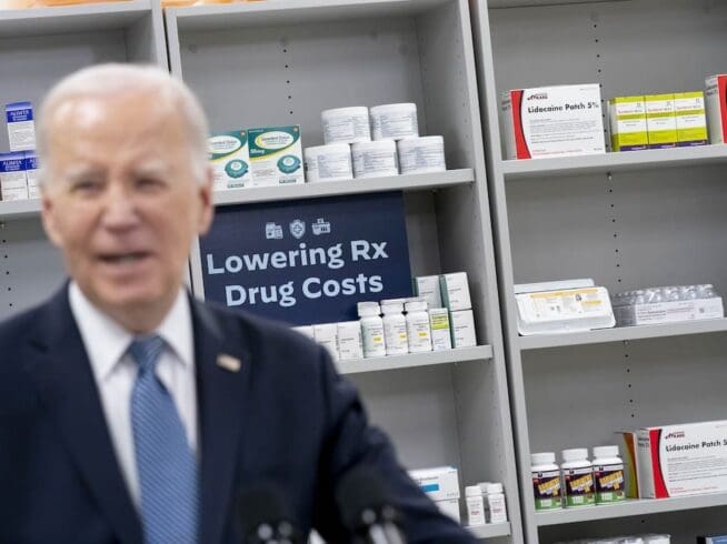 Items are displayed on shelves as President Joe Biden speaks about prescription drug costs at the National Institutes of Health in Bethesda, Md., Thursday, Dec. 14, 2023. (AP Photo/Andrew Harnik)