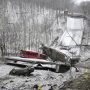 In a snowy landscape with bare trees, a bus sits atop the rubble of a collapsed bridge.