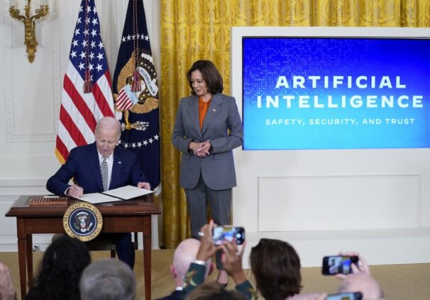 President Joe Biden signs an executive on artificial intelligence in the East Room of the White House, Monday, Oct. 30, 2023, in Washington. Vice President Kamala Harris looks on at right. (AP Photo/Evan Vucci)