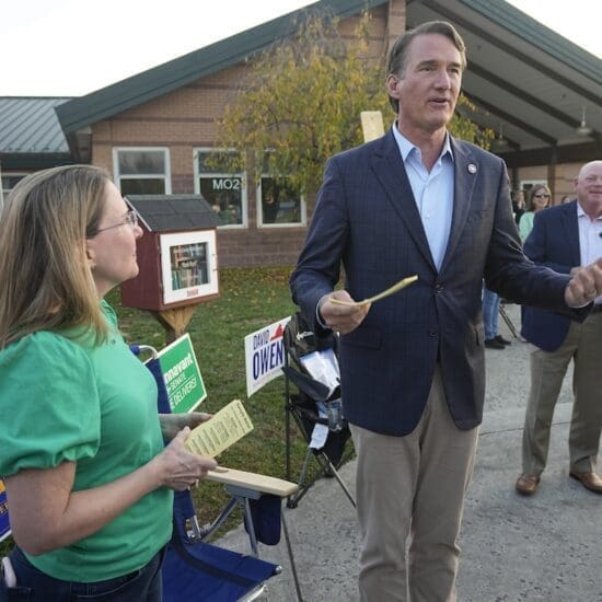 Virginia Gov. Glenn Youngkin, right, hands out sample ballots along with Virginia State Sen. Siobhan Dunnavant R-Henrico, as they greet voters at a polling station Tuesday Nov. 7, 2023, in Glenn Allen, Va. (AP Photo/Steve Helber)